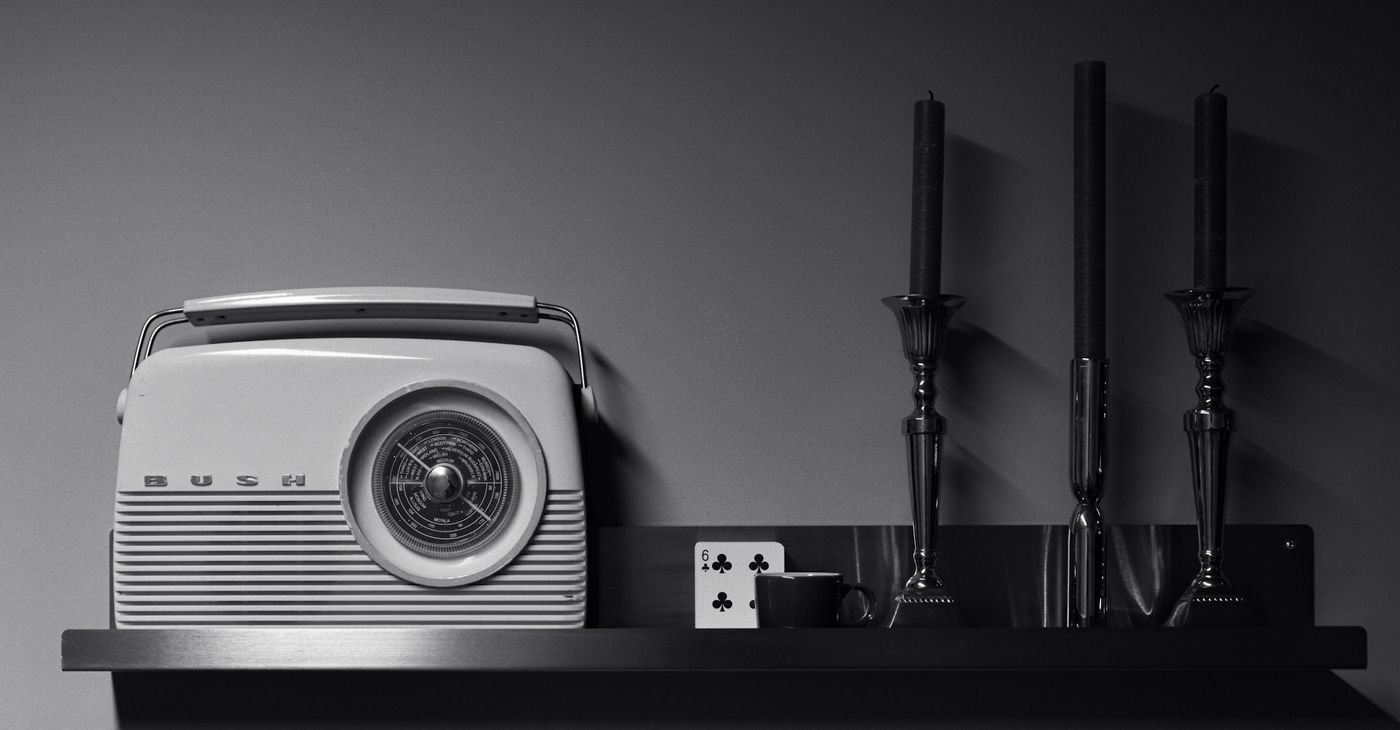 Styled prop shelf with a vintage radio and candlesticks.