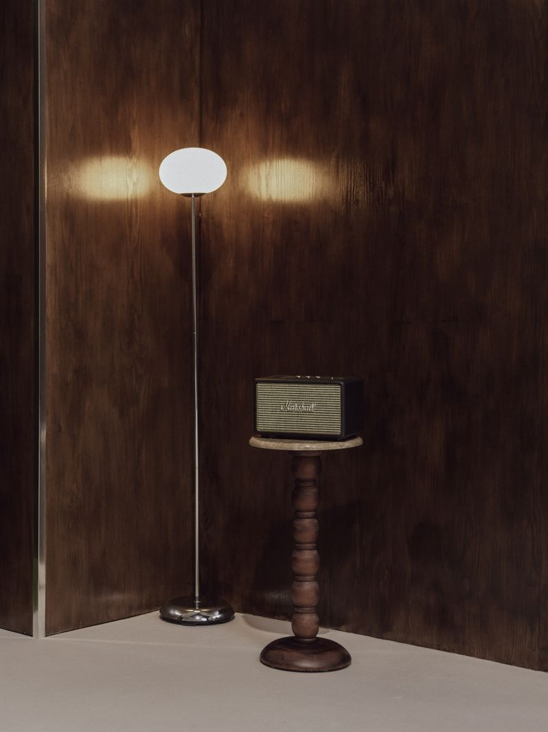 Warm lamp light against the walnut-panelled wall.